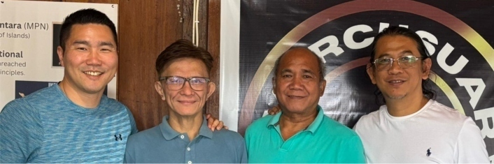 four men standing in a row smiling at camera