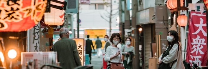 Face-masked Japanese people in city street.