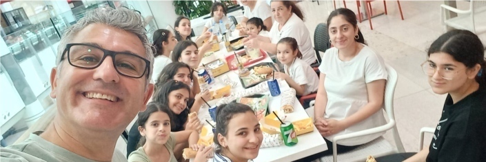 Man taking a selfee with group of girls in background