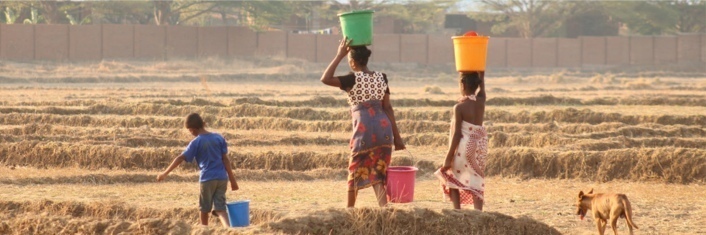 Africian women carrying baskets on their heads while working in the fields