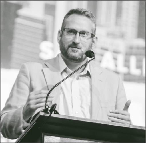 Black and white photo of Sam Allberry--a middle-aged man speaking from a podium