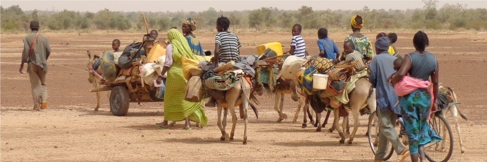 Group of refugees in the dessert walking and riding donkeys