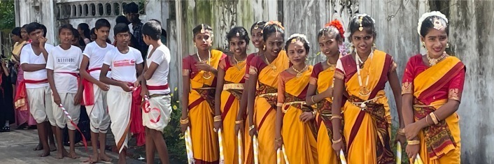A line of brightly dressed boys and girls ready for a ceremonial dance