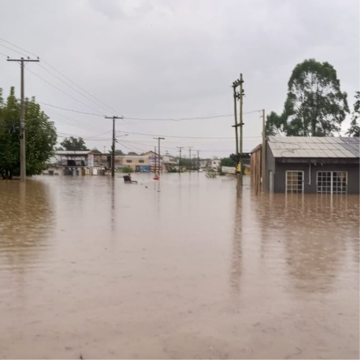 Brown murky flood waters cover a street in Brazil turning it into a river.