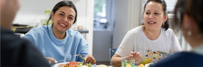 Two Colombian women eating together with friends